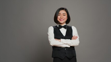 Asian woman hotel concierge wearing elegant uniform with bow, working in hospitality industry as a...