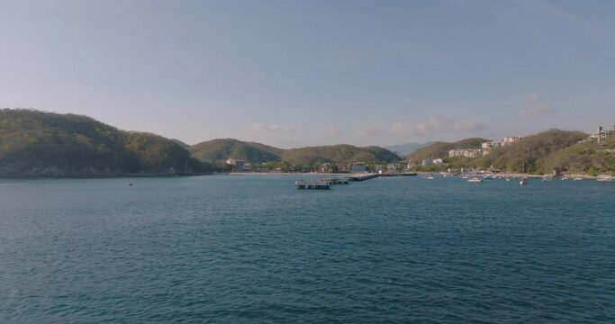 Vista del puerto desde el mar, atardecer en muelle de barco, Santa Cruz Huatulco