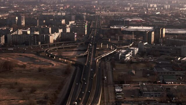 Drone shot of Riga city highway interchange with morning light reflecting on residential buildings and roads, Latvia