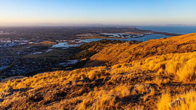sunset over christchurch city and avon heathcote estuary seen from the summit road near john britten reserve; 