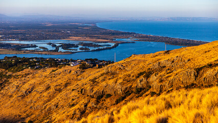 sunset over christchurch city and avon heathcote estuary seen from the summit road near john britten reserve; 