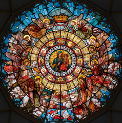 Fototapeta na wymiar MILAN, ITALY - MARCH 5, 2024: The stained glass top of the cupola with Madonna della Salute in the church Chiesa di San Camillo by Eugenio Cisterna (1900).