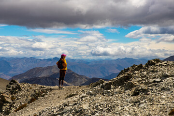 Naklejka premium brave hiker climbing a steep, highly challenging track to Castle Hilll Peak in Korowai/Torlesse Tussocklands Park, near Sheffield, Canterbury, new zealand south island, Mountains close to Christchurch