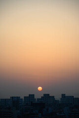 都市の夜明け。神戸市内から芦屋のビルがをのぞみ、ビルの上から朝日が昇る。
