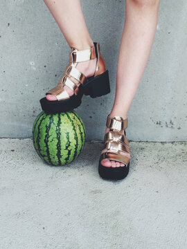 Playing football with watermelon with copper metallic heels 