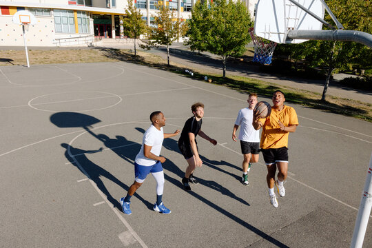A group of friends playing basketball together outside.