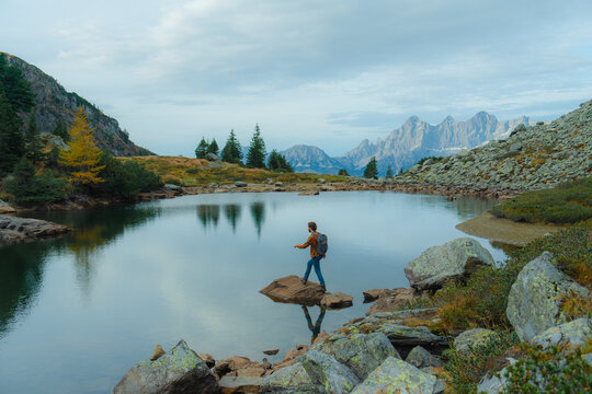 Man standing near the alpine lake in Alps 