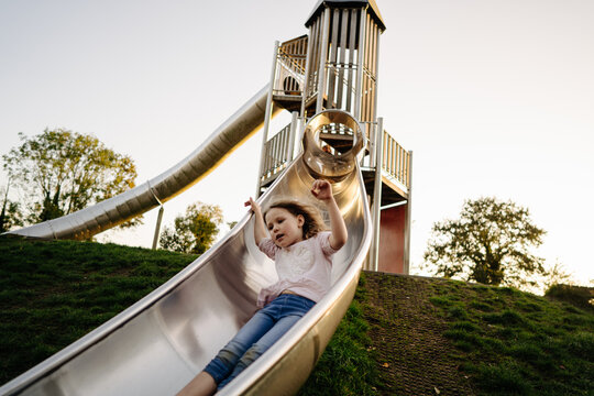 Golden hour joy: girl's playful slide adventure