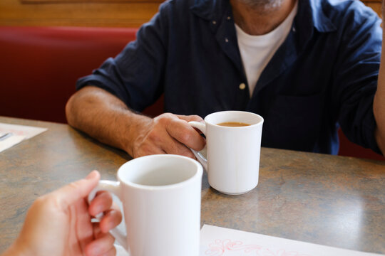 Anonymous people drinking coffee in diner