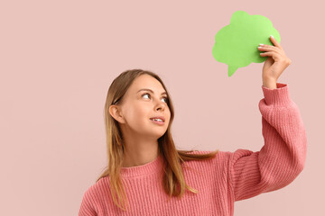 Pretty young woman holding blank speech bubble on pink background