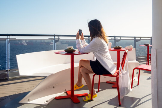 A woman taking photos on the terrace of a cruise ship