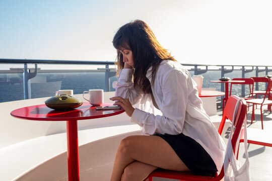 A woman texting on her mobile on the terrace of a cruise ship