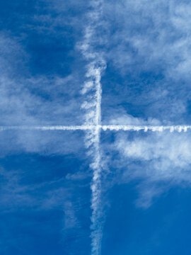 A white plus sign in the blue sky