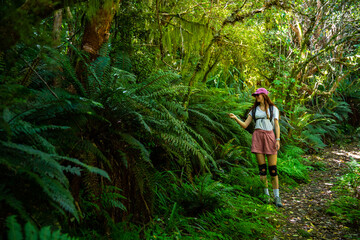 hiker girl enjoys a walk through native forest full of unique vegetation in otepatotu nature...