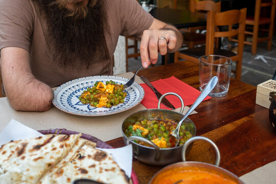 Male eating butter curry chicken at restaurant 