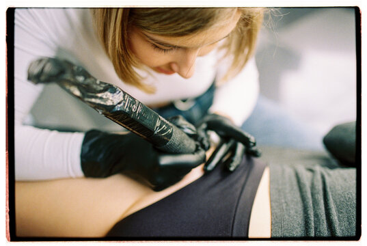 Closeup of woman tattooer making a tattoo 