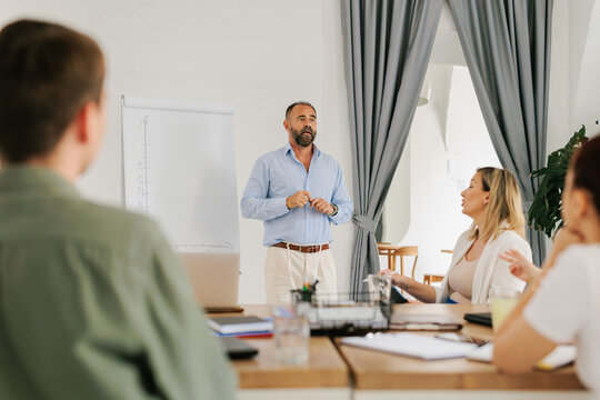 Adult businessman using flipchart board on a meeting