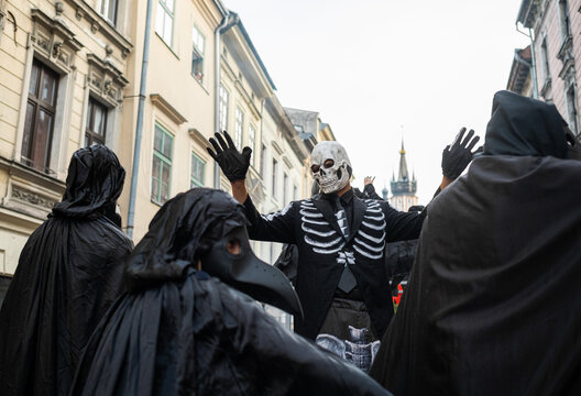 A man in a dead man's costume with plague doctors on Halloween