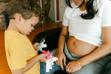 pregnant mother talking to her little boy 