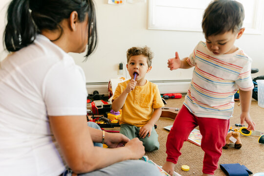 little boys playing with their  mother in playroom 