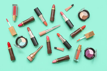 Eyeshadows palettes with eyeliners and lipsticks on turquoise background