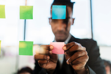 Black male executive with sticky notes in creative office