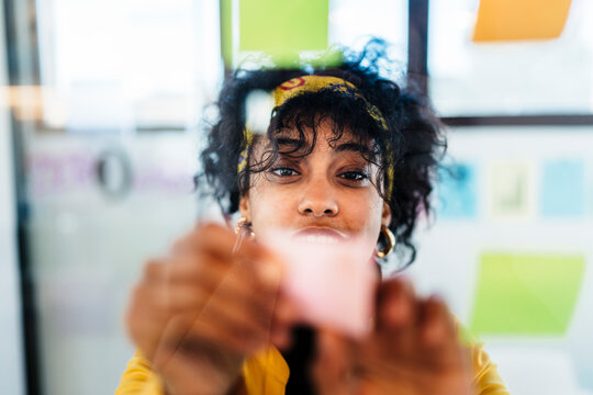 Female executive with sticky notes in creative workspace