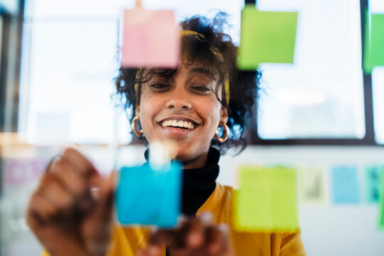 Female executive with sticky notes in creative workspace
