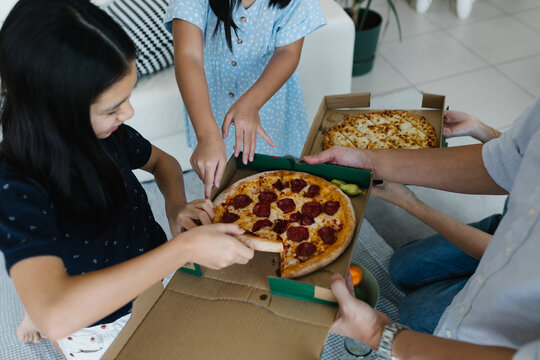 Family sharing delivered pizza at home
