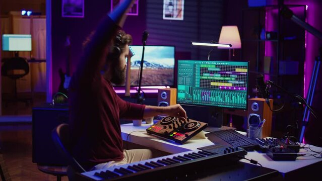 Music producer mixing individual tracks into a stereo in home studio, artist adjusting levels, panning and special effects to achieve a balanced audio. Musician does acoustical engineering. Camera A.