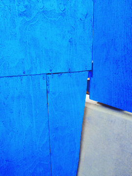 Corner of blue painted wood wall and concrete block