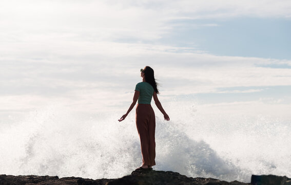 Woman standing next to impressive water splash