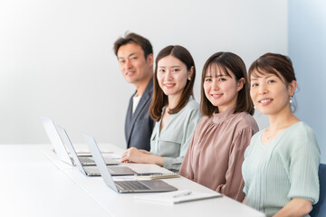 オフィスでパソコンを使う仕事をするビジネスマンとビジネスウーマン（同僚・仲間）
