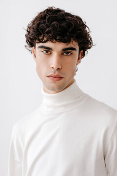 Serious young man looking at camera over white background