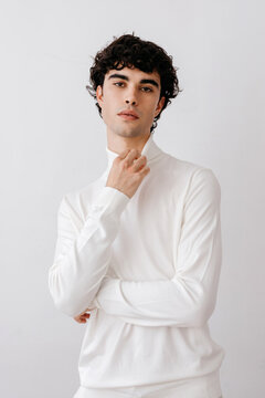 Confident young man in white shirt touching neck