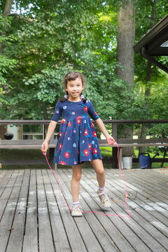 Asian little girl, practicing a jump rope