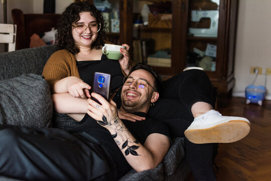 Couple at home watching social media videos and laughing