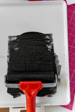 Roller with black paint for linocut printing