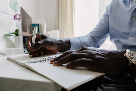 A man writing down notes in a notebook 