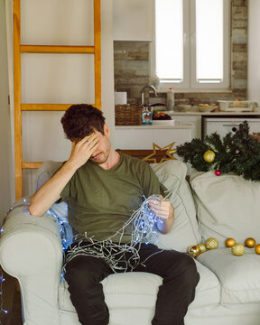A young man unravels the Christmas lights 