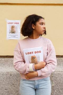Black teen holding lost dog placards