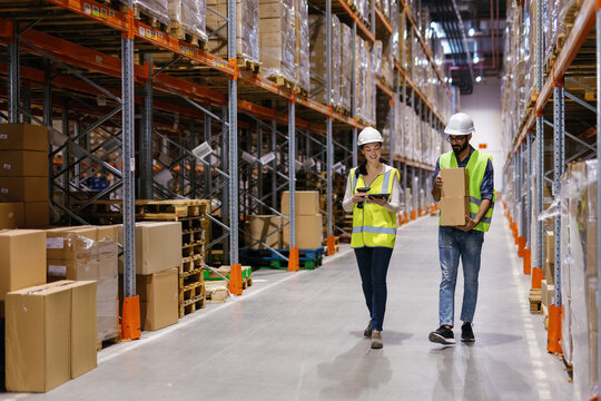 Coworkers together checking goods with boxes