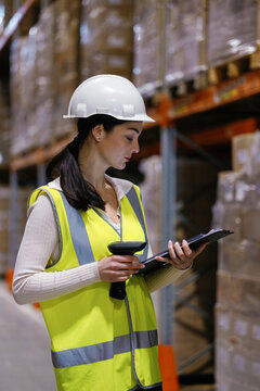 Female storage employee using business device