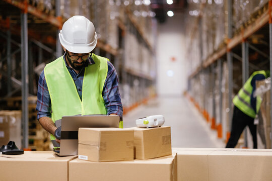 Worker using laptop in distribution center 
