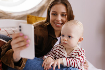 Modern motherhood toddler smartphone selfie digital era smile remotely