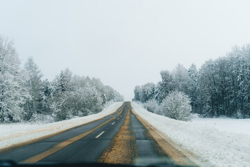 Winter Road Trip.Snowy forest drive on a slippery empty road. 