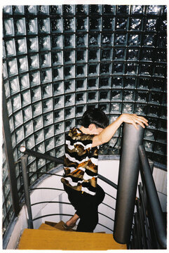 Anonymous androgynous person walking down helical staircase