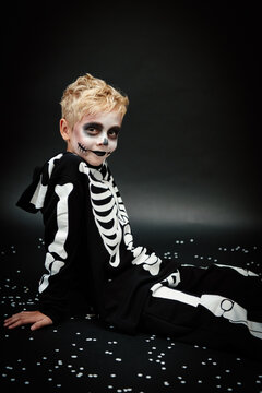 Boy in skeleton outfit for halloween, posing in a studio