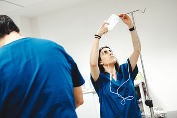 Assistant preparing intravenous medication near veterinarian in clinic