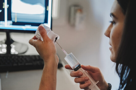 Veterinarian filling syringe with medicine in clinic